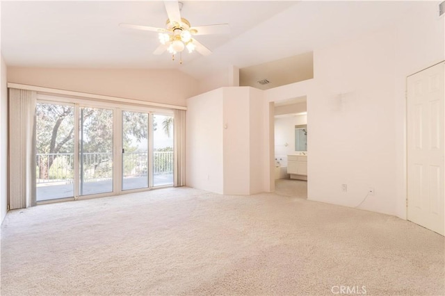 empty room featuring ceiling fan, vaulted ceiling, and light carpet