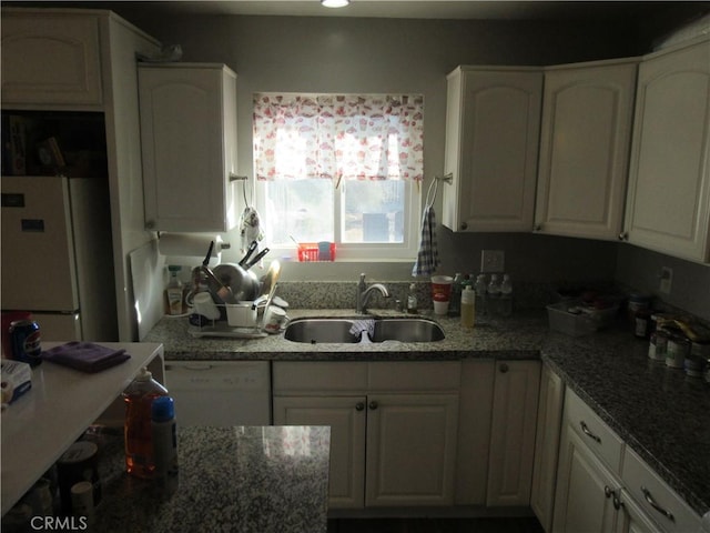 kitchen featuring white cabinetry, white appliances, dark stone counters, and sink