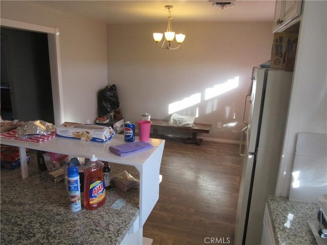 dining space with an inviting chandelier and dark hardwood / wood-style flooring