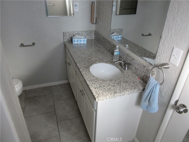 bathroom featuring vanity, tile patterned flooring, and toilet