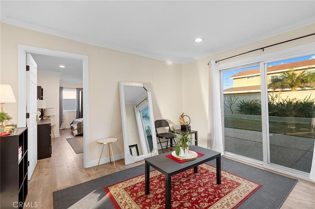 sitting room featuring hardwood / wood-style floors, a wealth of natural light, and ornamental molding