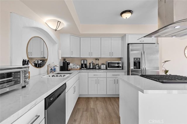 kitchen with sink, white cabinetry, island range hood, light wood-type flooring, and appliances with stainless steel finishes