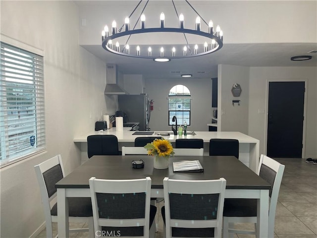 dining area with light tile patterned floors and a chandelier