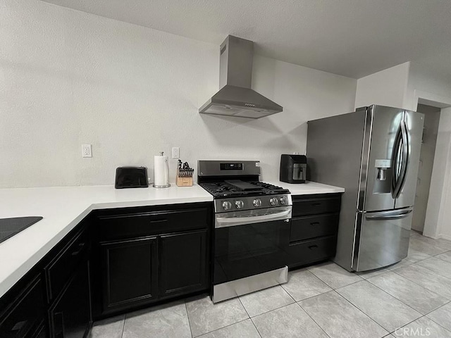 kitchen with stainless steel appliances, wall chimney range hood, and light tile patterned floors