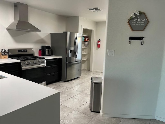 kitchen featuring stainless steel appliances, light tile patterned flooring, and wall chimney range hood