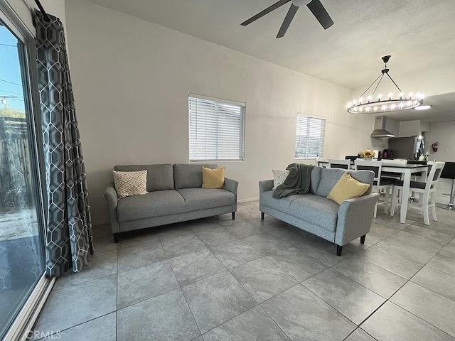 living room featuring ceiling fan with notable chandelier