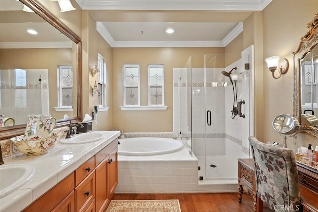 bathroom featuring vanity, wood-type flooring, ornamental molding, and shower with separate bathtub