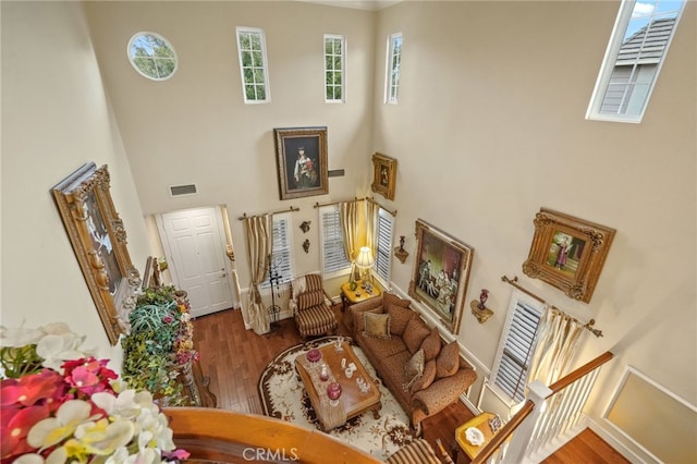 living room with hardwood / wood-style flooring and a towering ceiling