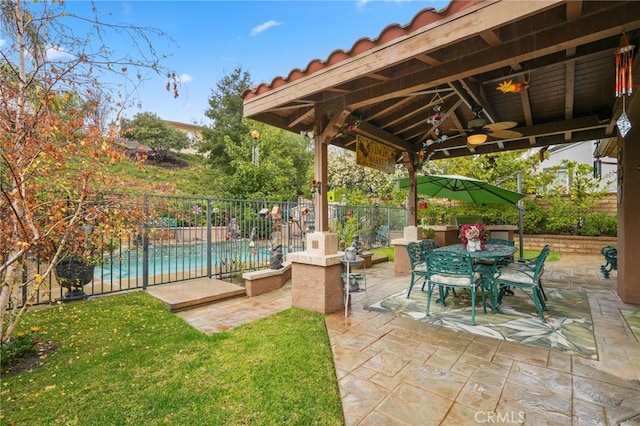 view of patio with ceiling fan and a fenced in pool