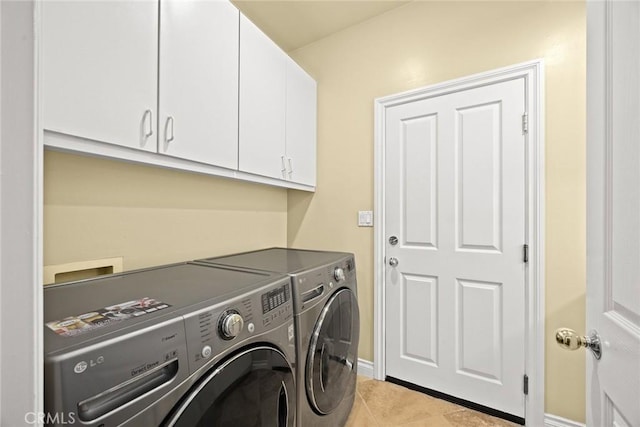 washroom with cabinets, washer and dryer, and light tile patterned floors