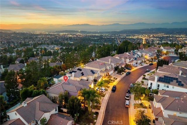 aerial view at dusk featuring a mountain view