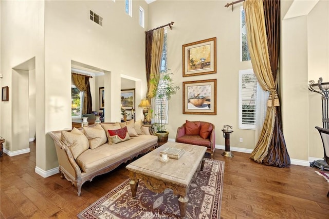 sitting room featuring hardwood / wood-style flooring and a towering ceiling