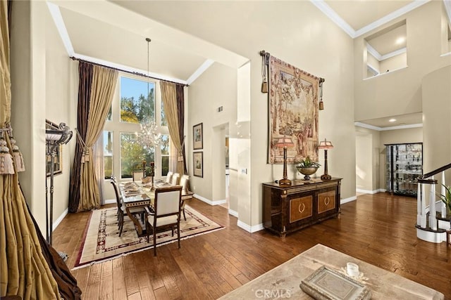 dining area featuring crown molding, a towering ceiling, dark wood-type flooring, and a notable chandelier