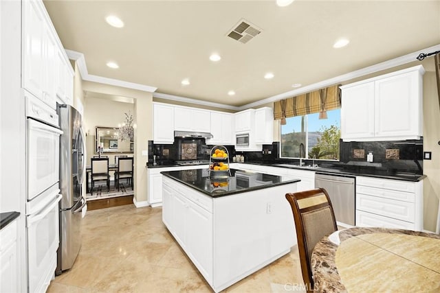 kitchen featuring appliances with stainless steel finishes, sink, a kitchen island, and white cabinets