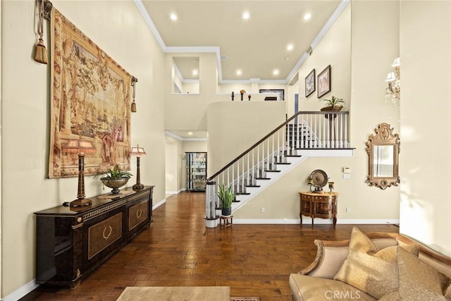 foyer entrance featuring dark hardwood / wood-style flooring, crown molding, and a high ceiling