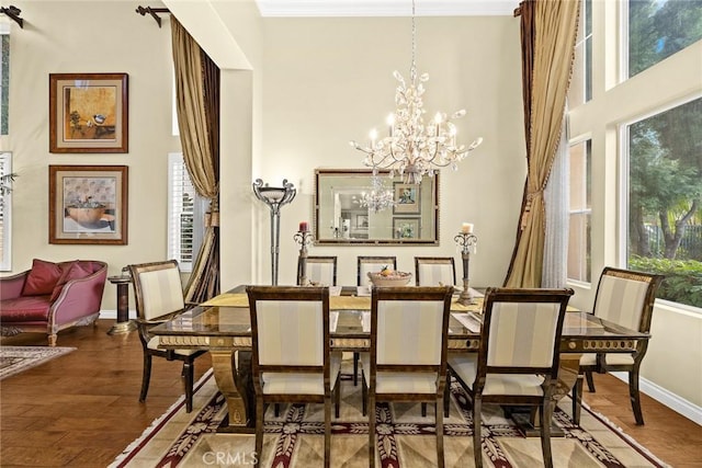 dining space featuring an inviting chandelier, hardwood / wood-style floors, and a high ceiling