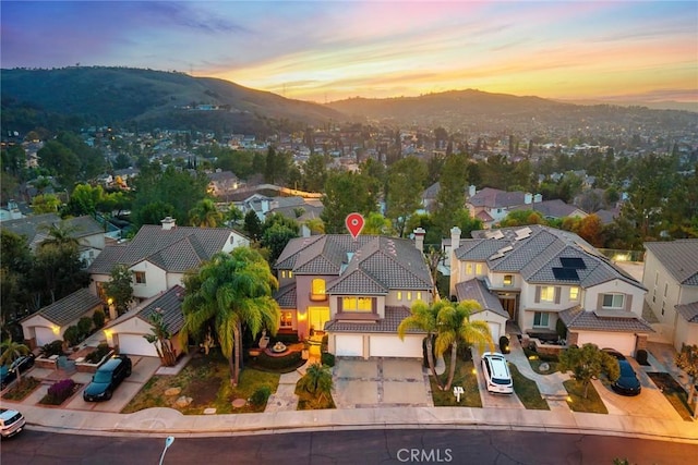 aerial view at dusk featuring a mountain view