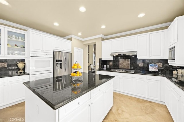 kitchen featuring white cabinetry, appliances with stainless steel finishes, and dark stone counters