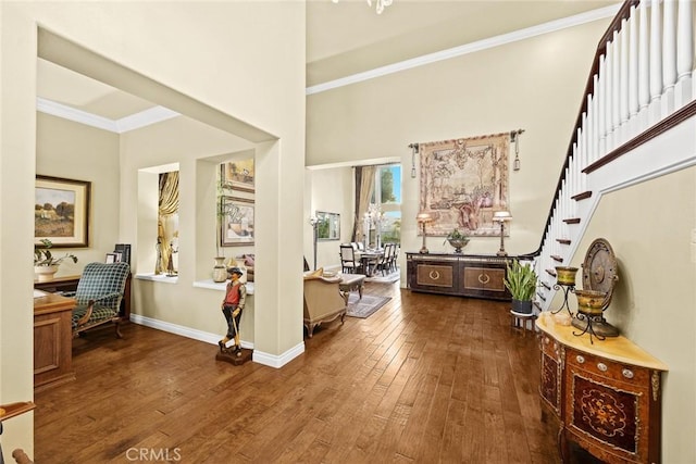 foyer featuring hardwood / wood-style flooring, a towering ceiling, and crown molding