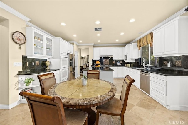 kitchen featuring sink, crown molding, appliances with stainless steel finishes, backsplash, and white cabinets