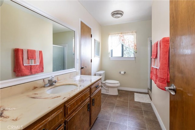 bathroom with tile patterned floors, vanity, toilet, and a shower with door