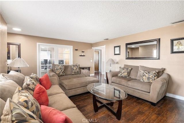 living room featuring dark wood-type flooring and a textured ceiling