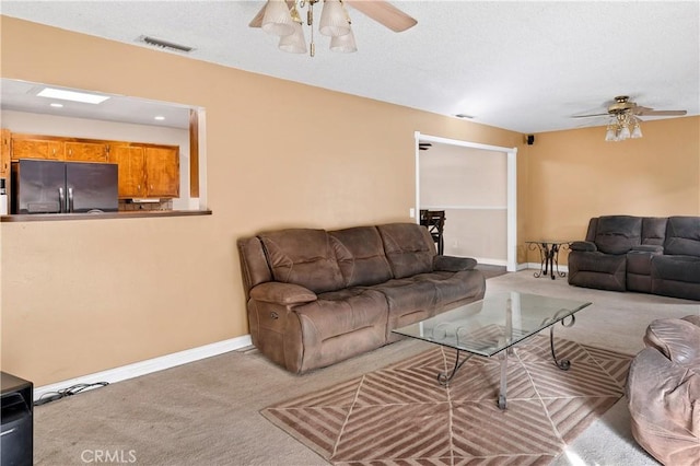 carpeted living room with ceiling fan