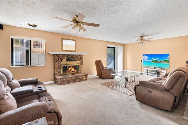 living room featuring a stone fireplace, light carpet, a textured ceiling, and ceiling fan