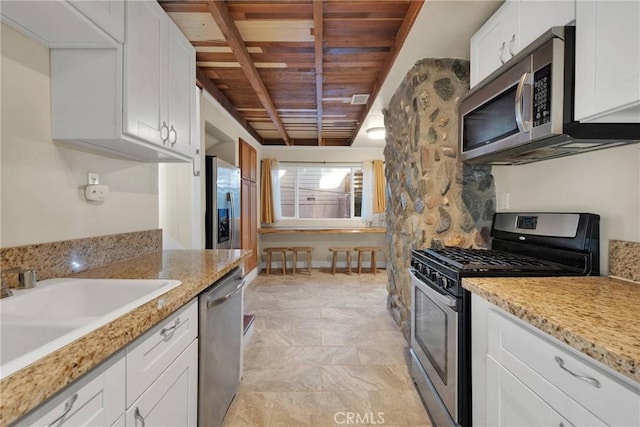 kitchen featuring sink, white cabinets, light stone counters, stainless steel appliances, and wooden ceiling