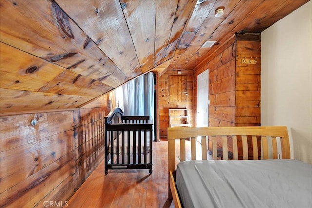 bedroom with wood ceiling and wood walls