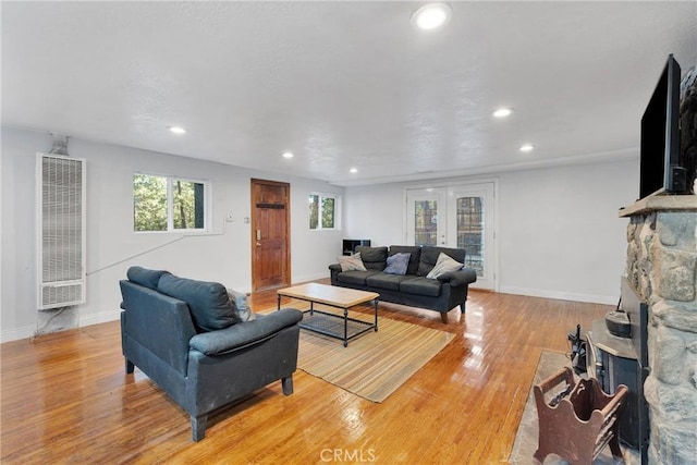 living room featuring french doors, a fireplace, and light hardwood / wood-style floors