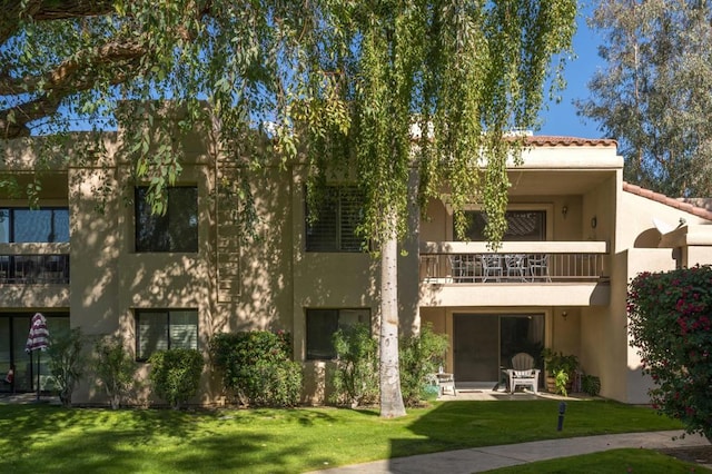 exterior space with a balcony and a yard