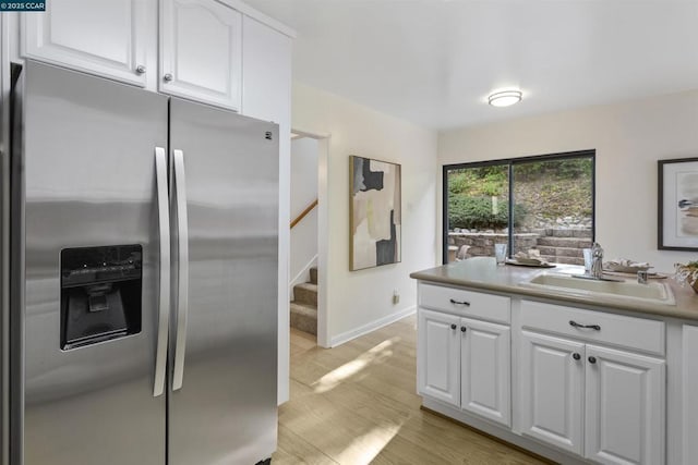 kitchen with white cabinetry, sink, light hardwood / wood-style flooring, and stainless steel fridge with ice dispenser