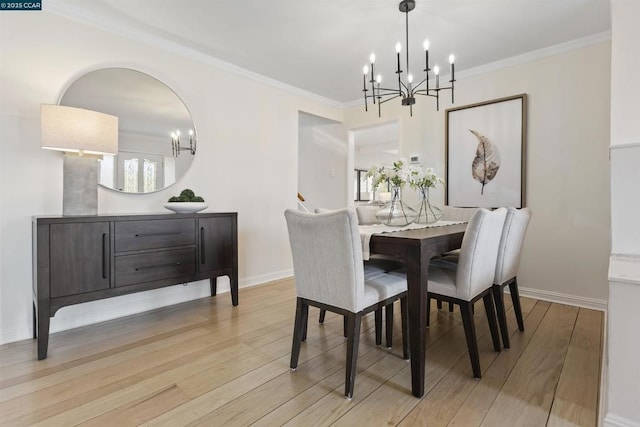 dining space with crown molding, a chandelier, and light hardwood / wood-style floors