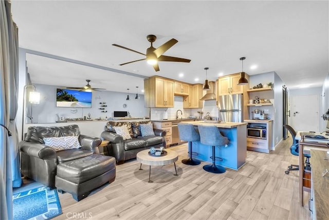 living room featuring a ceiling fan, recessed lighting, and light wood finished floors