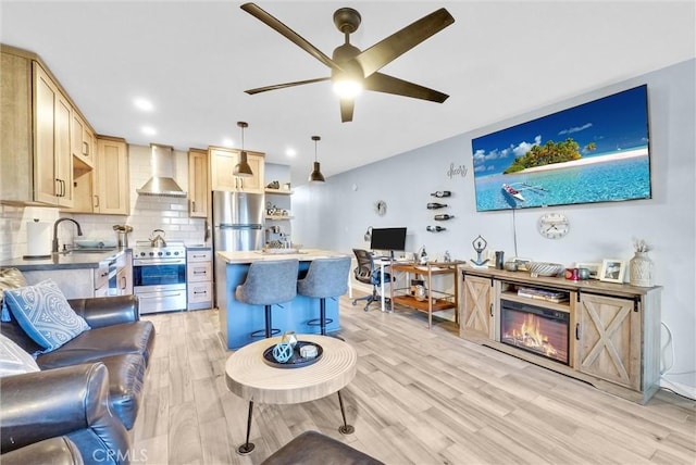 living room featuring light wood-style floors, a ceiling fan, and recessed lighting