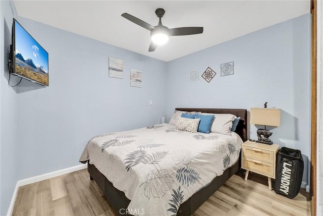 bedroom featuring ceiling fan, light wood-style flooring, and baseboards