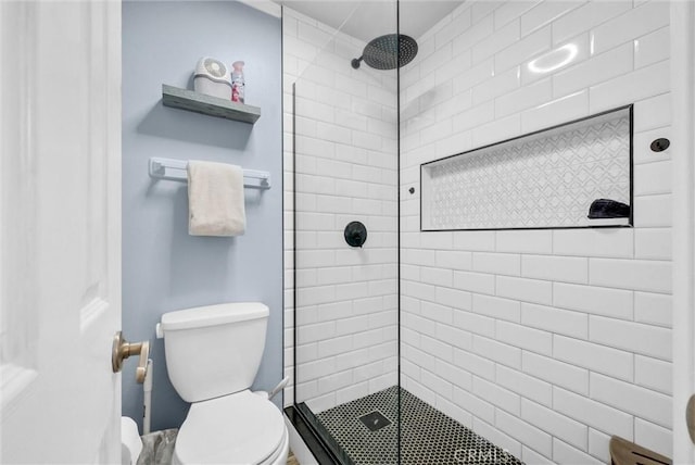 bathroom with a shower stall and toilet