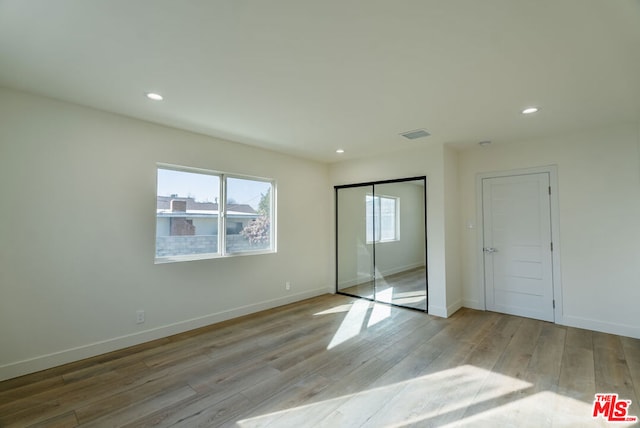 unfurnished bedroom featuring light hardwood / wood-style floors and a closet