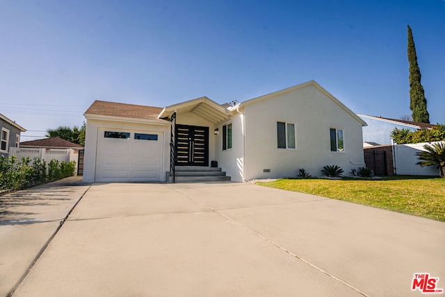 view of front of property with a garage and a front lawn