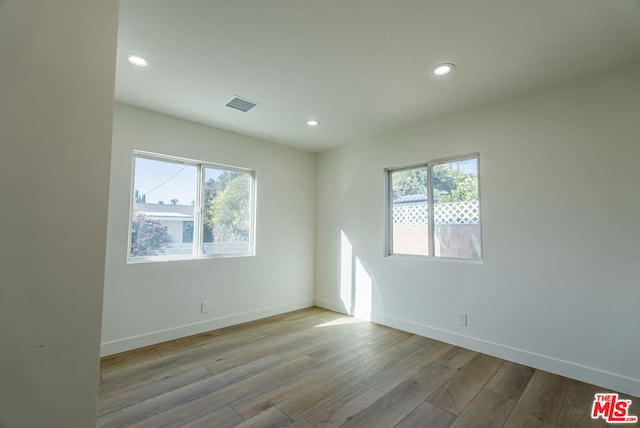 spare room featuring a healthy amount of sunlight and light wood-type flooring