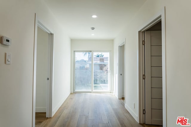 corridor with light hardwood / wood-style floors