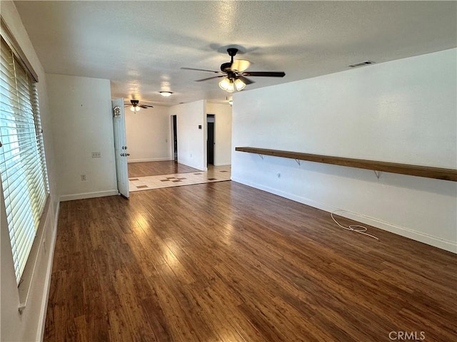 unfurnished room featuring a textured ceiling, dark wood-type flooring, and ceiling fan