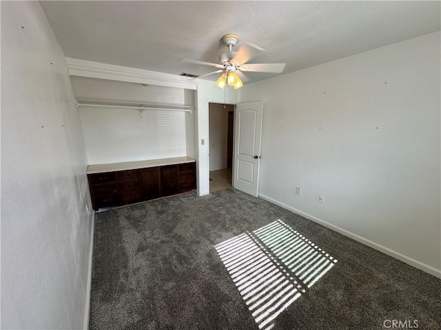 unfurnished bedroom featuring ceiling fan and dark colored carpet