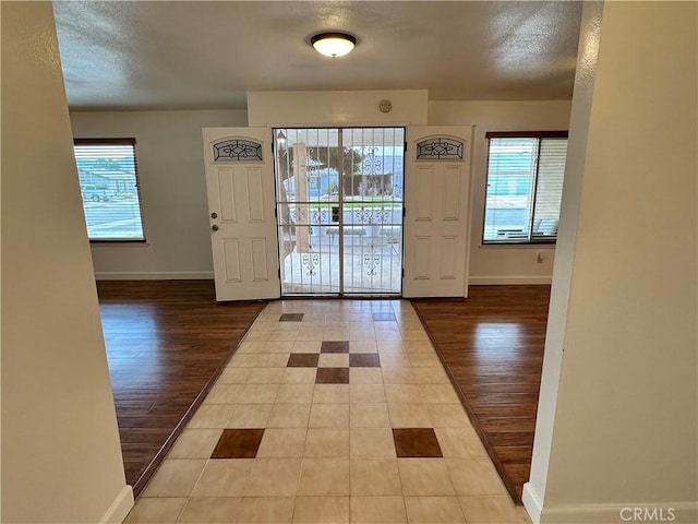 foyer featuring a textured ceiling and light hardwood / wood-style floors