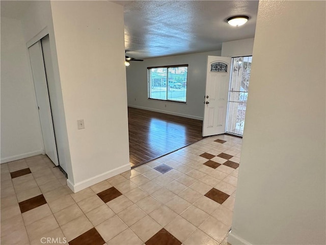 tiled entrance foyer featuring ceiling fan and a textured ceiling