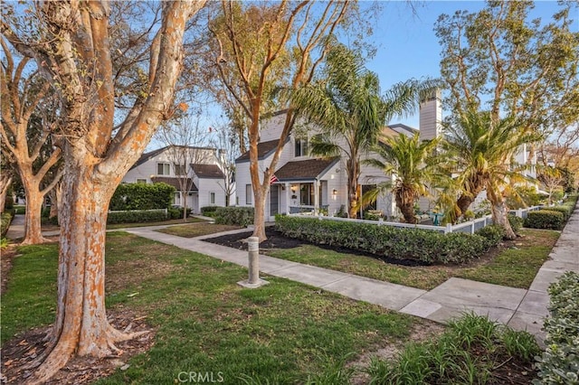 view of front of house with a fenced front yard, a residential view, and a front lawn