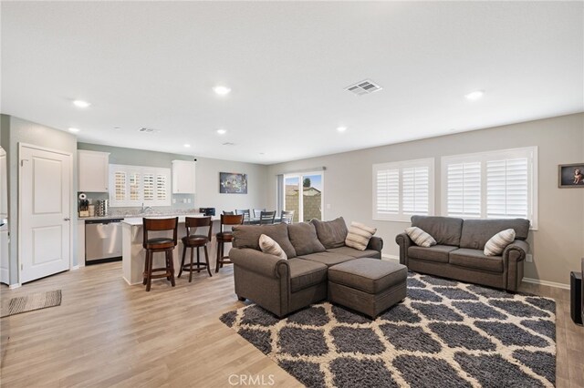 living room with sink and light hardwood / wood-style floors