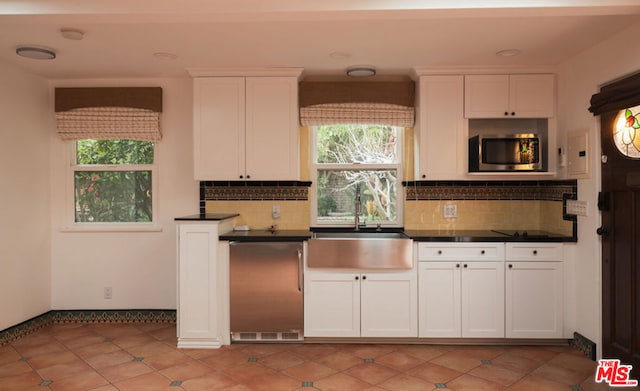 kitchen with white cabinetry, sink, and a wealth of natural light