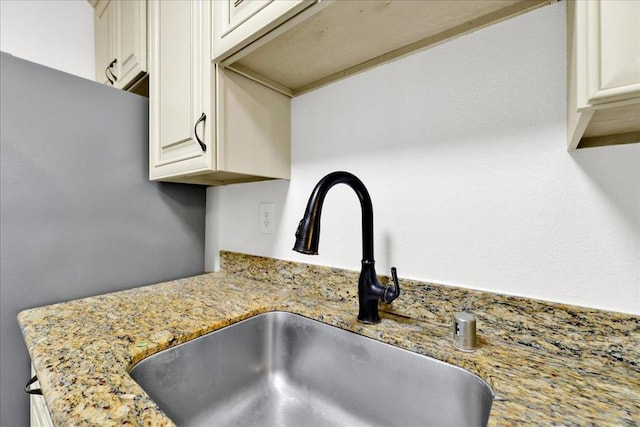 room details featuring light stone counters and sink